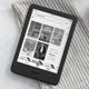 The basic model Amazon Kindle sitting on a napkin on a breakfast table.